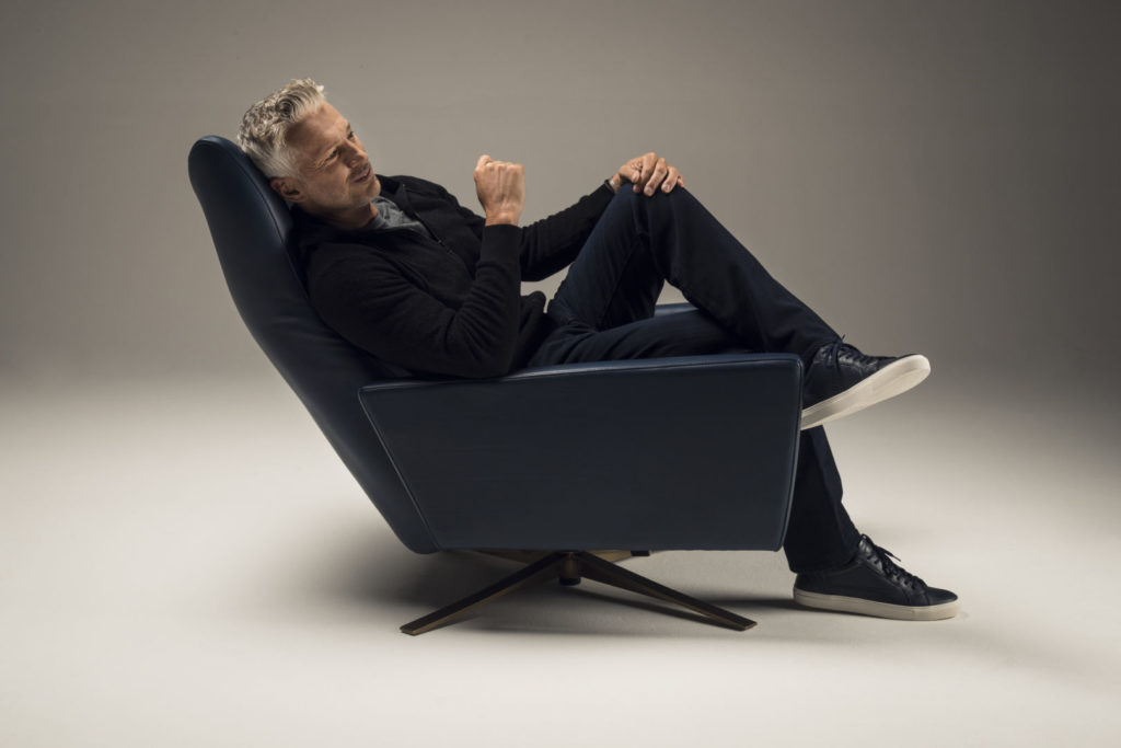 Man sitting in a Comfort Air Stratus Chair with legs crossed. Side view.