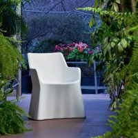 The white Phantom chair creates a classic and clean look. It creates a sharp contrast against a green landscape.